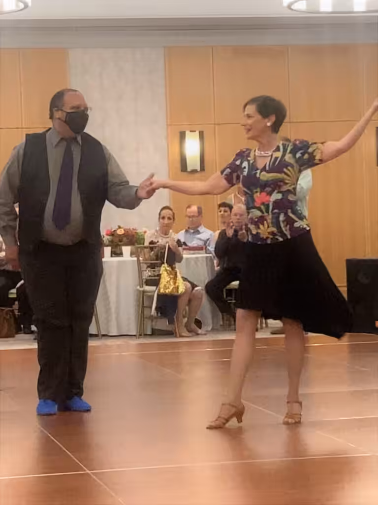 A middle-aged couple dancing in a ballroom.