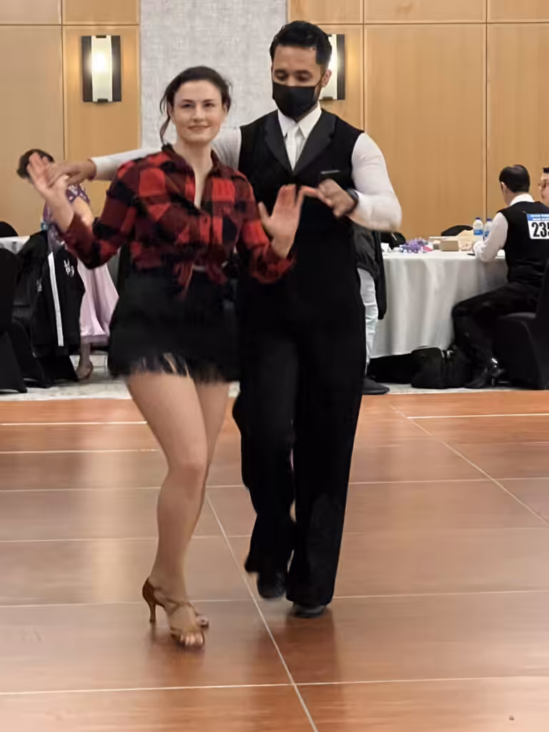 A dance couple performing at a ballroom event.