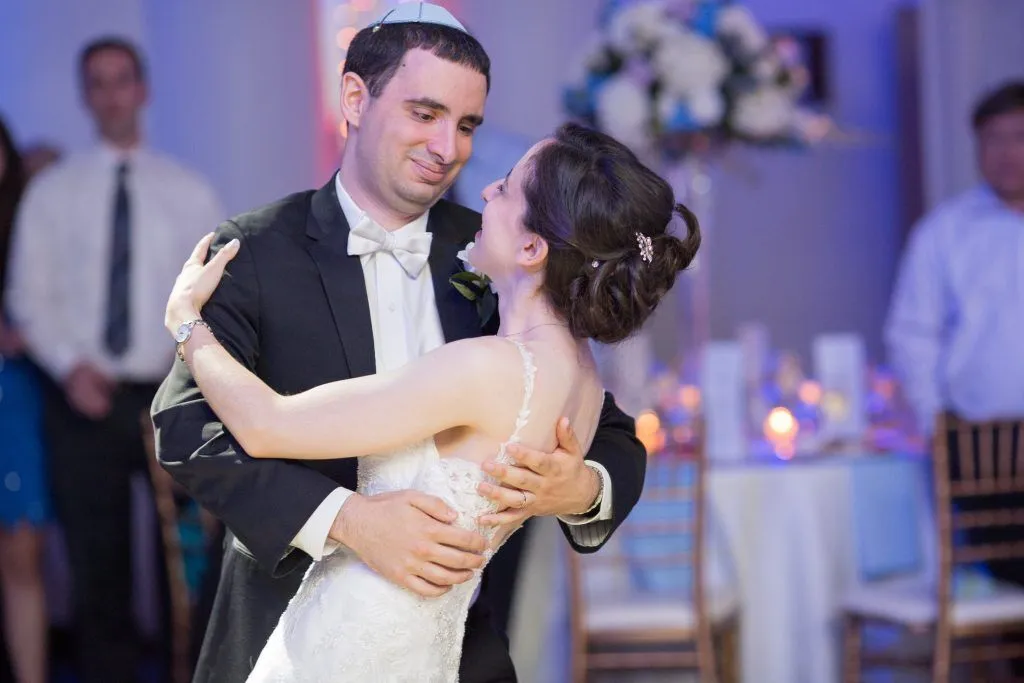 Bride and groom dance closely at their wedding.