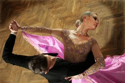 A couple of professional dancers perform Viennese waltz wearing dance costumes for the occasion.