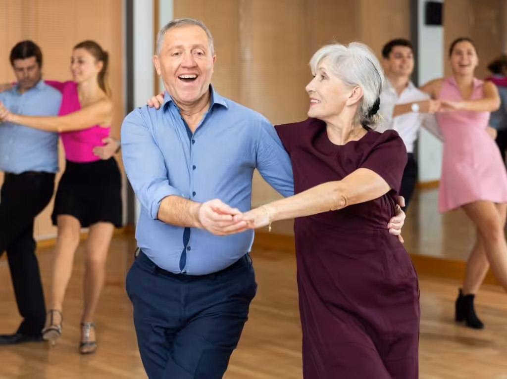 Couples dancing joyfully in dance class.