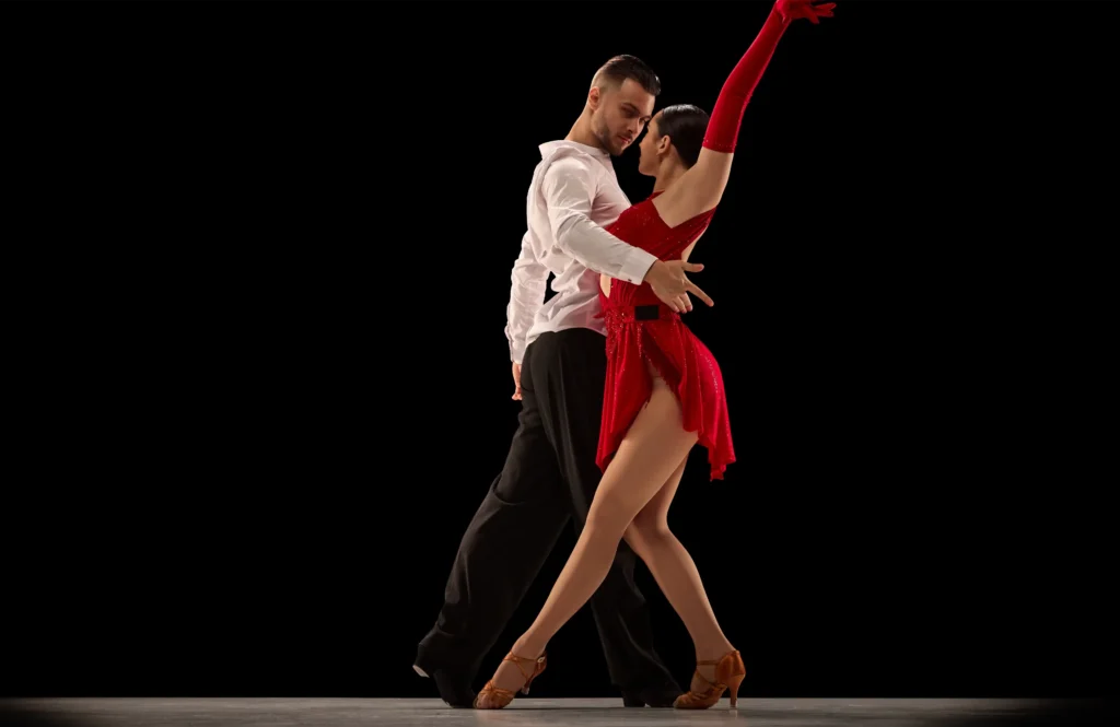 Couple dancing tango in elegant attire.