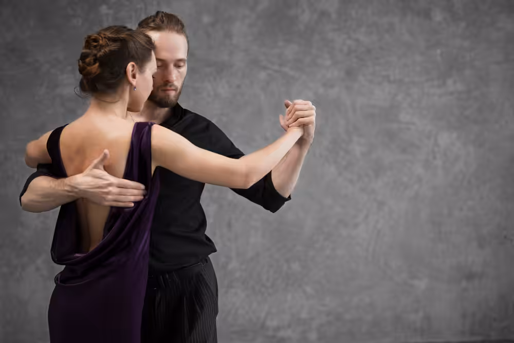 Couple dancing closely against gray background