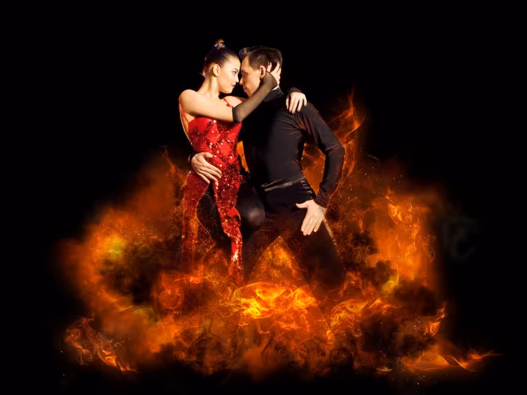 Dancers in fiery embrace on stage.