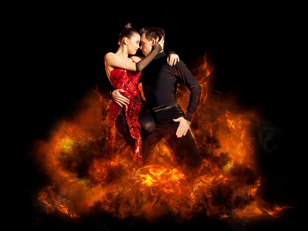 Dancers in fiery embrace on stage.