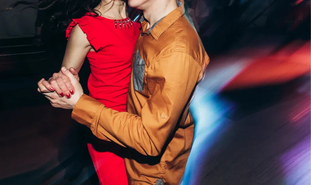 Couple dancing closely at nightclub with motion blur